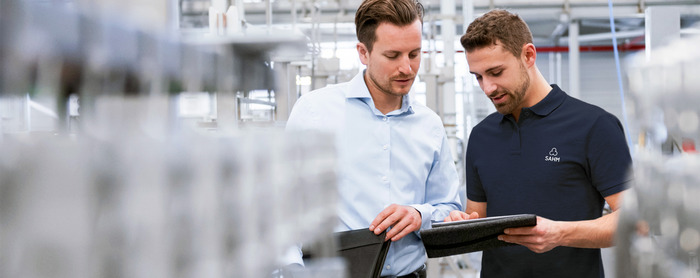 Two employees talking about documents in a shop floor